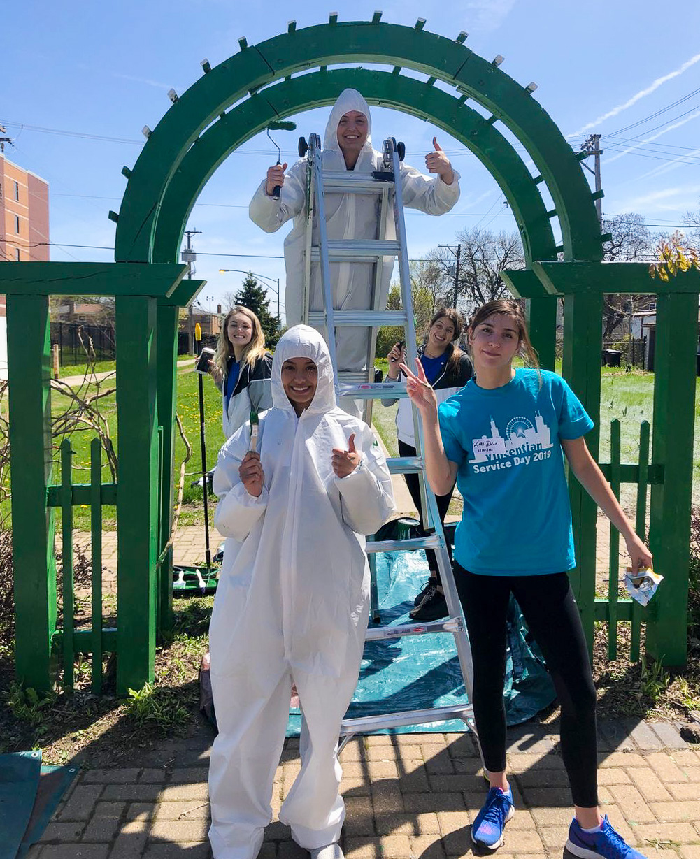 Mattie Norris, Mackenzie Savage, Brittany Maxwell, Natalie Hayward and Katie Dolan, players on the women’s Volleyball team, painted exterior fencing at Neighbor Space – Chicago. (DePaul University Athletics)